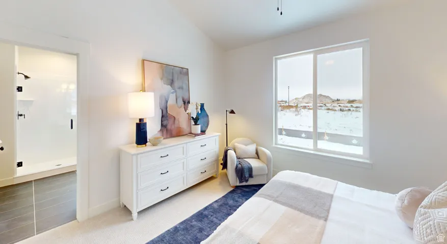 Bedroom featuring light carpet and vaulted ceiling