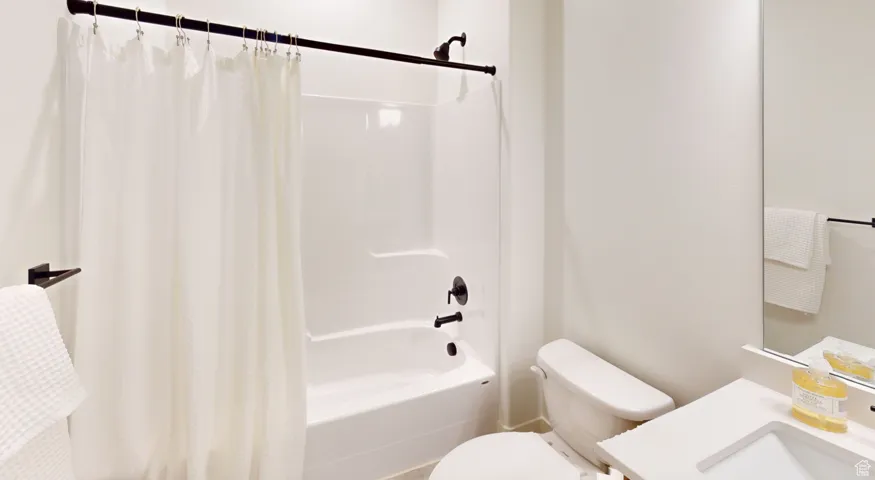 Full bathroom with shower / tub combo with curtain and vanity