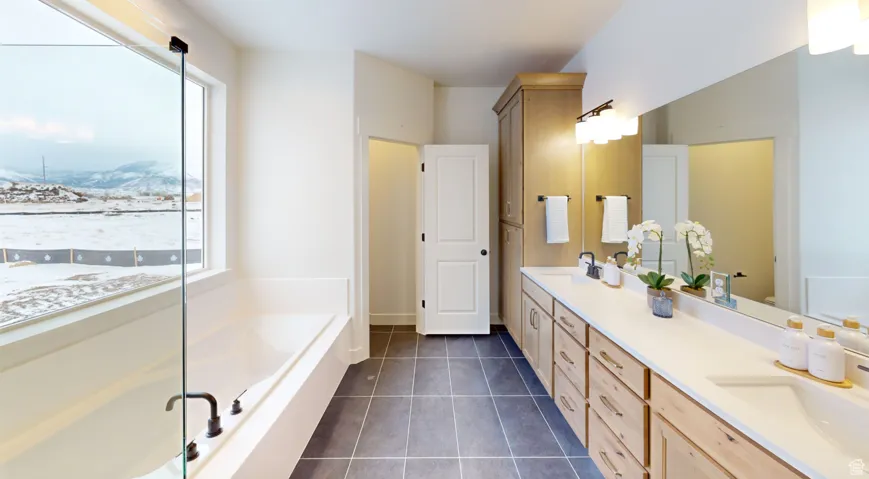 Full bath with a bath, double vanity, dark tile patterned flooring, a walk in shower, and a mountain view