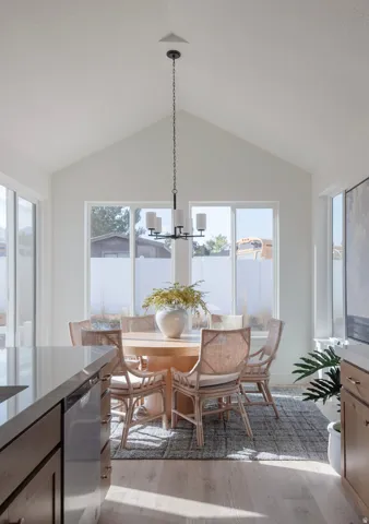 Dining space featuring light wood finished floors, lofted ceiling, and a chandelier