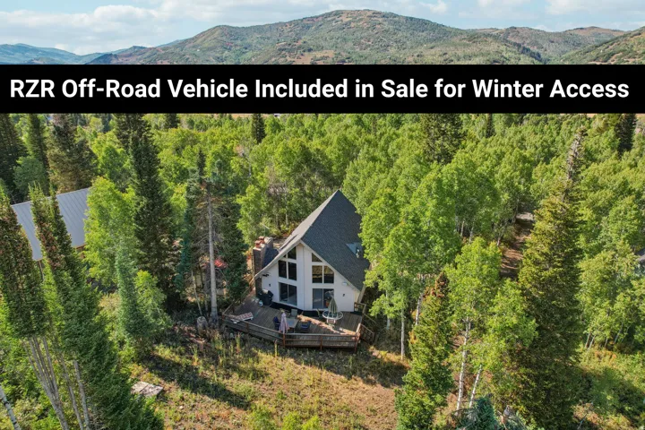 A-frame property with an expansive deck surrounded by mature trees