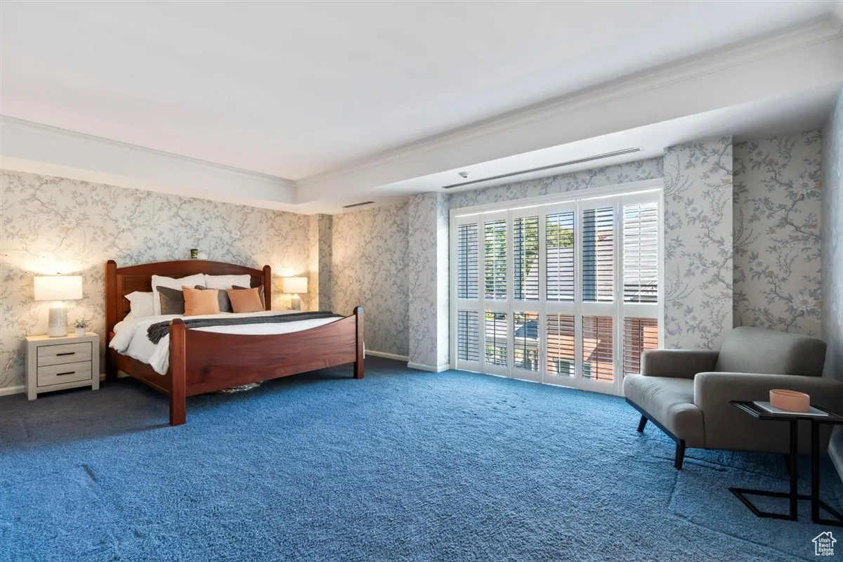 Bedroom with wallpapered walls, carpet flooring, ornamental molding, and access to outside