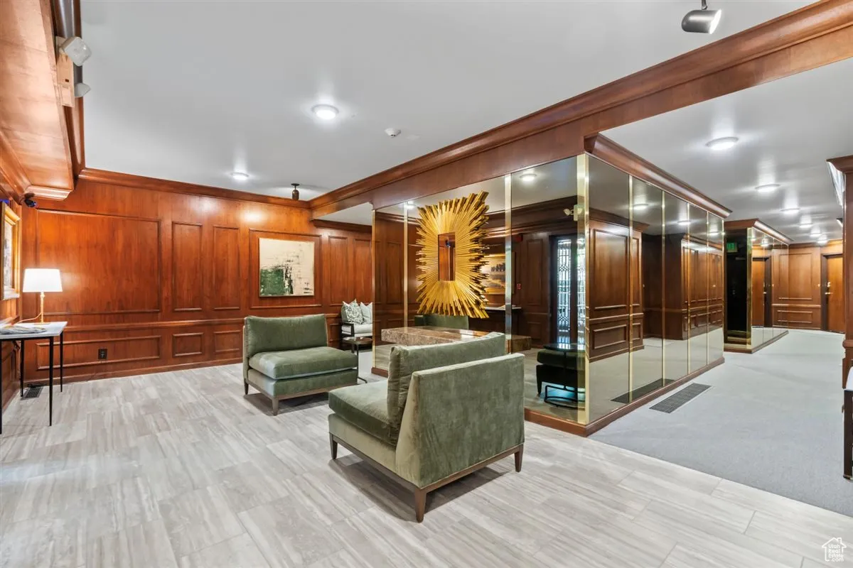 Common area featuring ornamental molding and wood walls