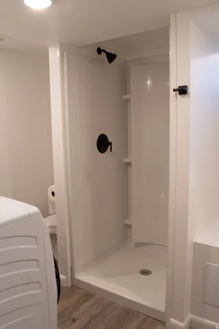 New bathroom with Contemporary shower stall featuring a matte black shower head and control,