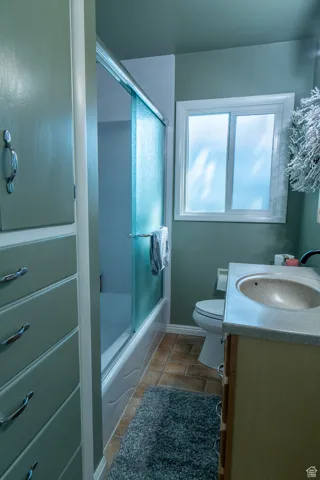 Full bathroom featuring shower / bath combination with glass door, vanity