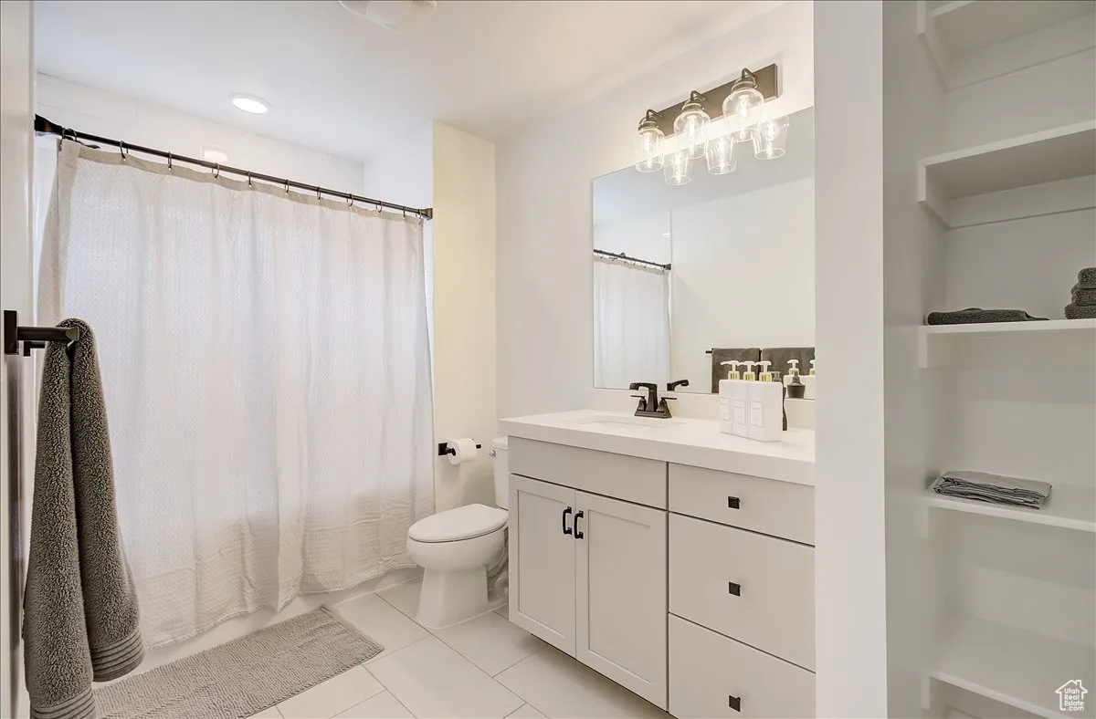 Full bathroom with light tile patterned flooring, vanity, shower / bath combo, and recessed lighting