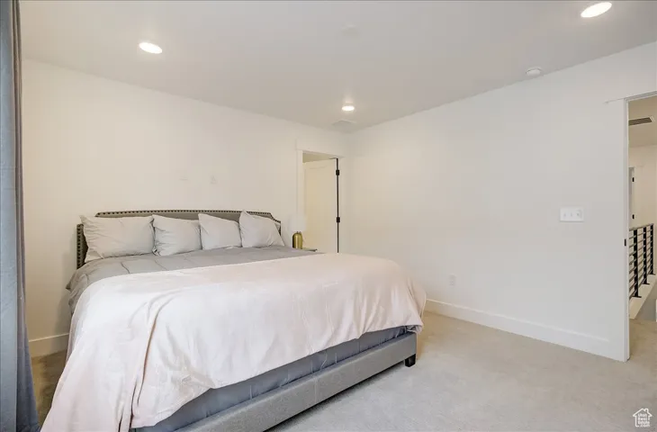 Bedroom with light carpet and recessed lighting