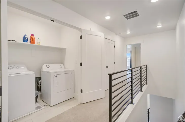 Washroom with carpet flooring, tile patterned flooring, recessed lighting, and washer and dryer
