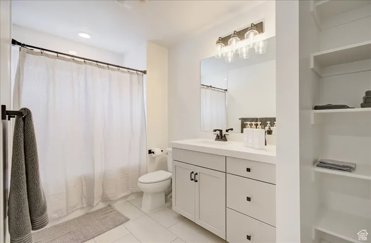 Full bathroom with light tile patterned flooring, vanity, shower / bath combo, and recessed lighting