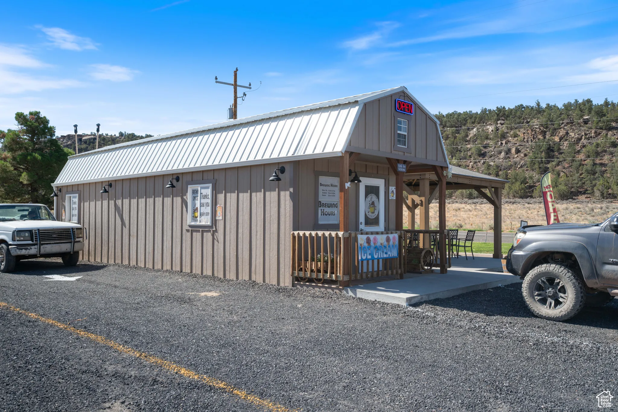 View of front of home featuring a gambrel roof, a metal roof, and board and batten siding