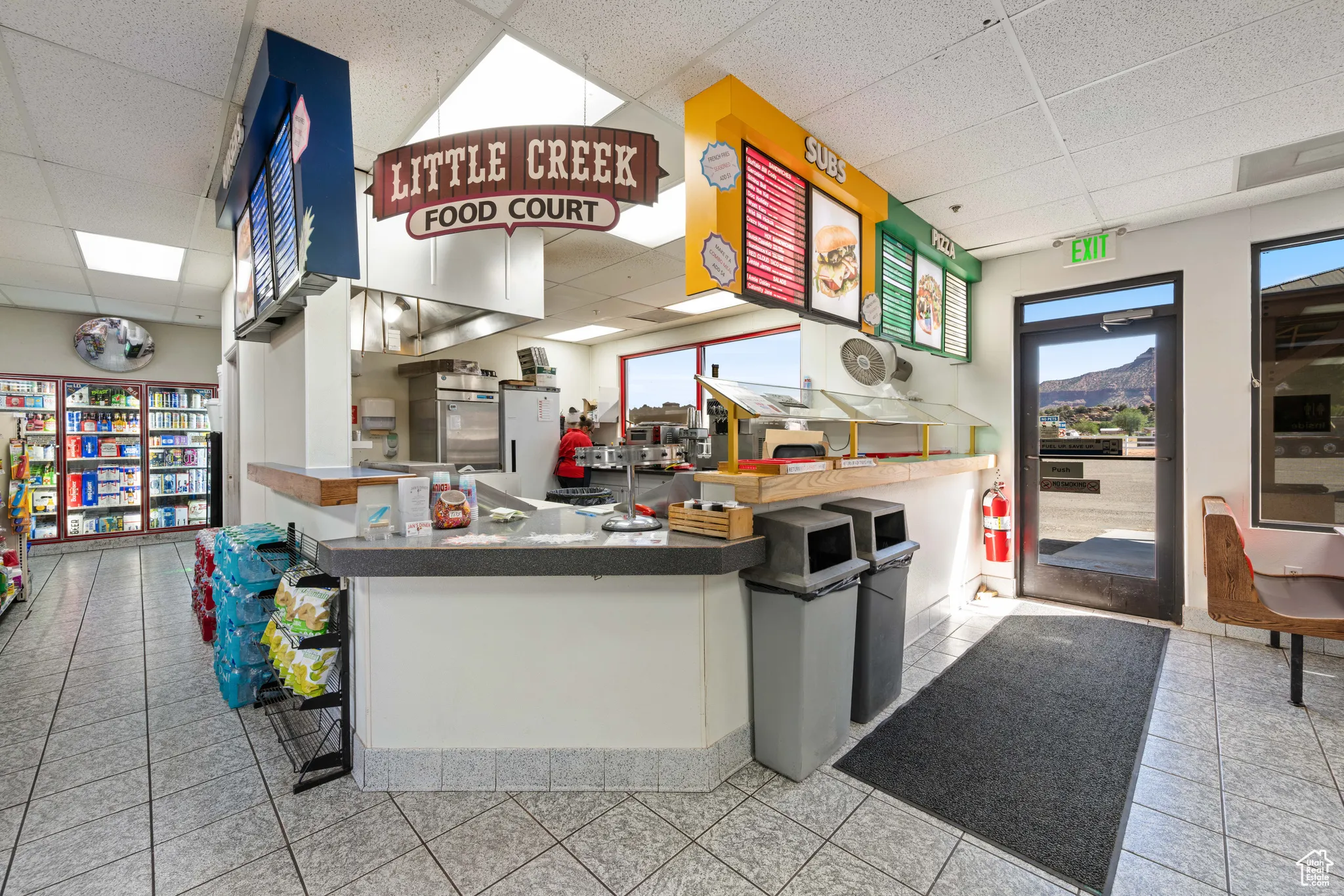 Kitchen with a drop ceiling, white cabinetry, light tile patterned flooring, and a peninsula