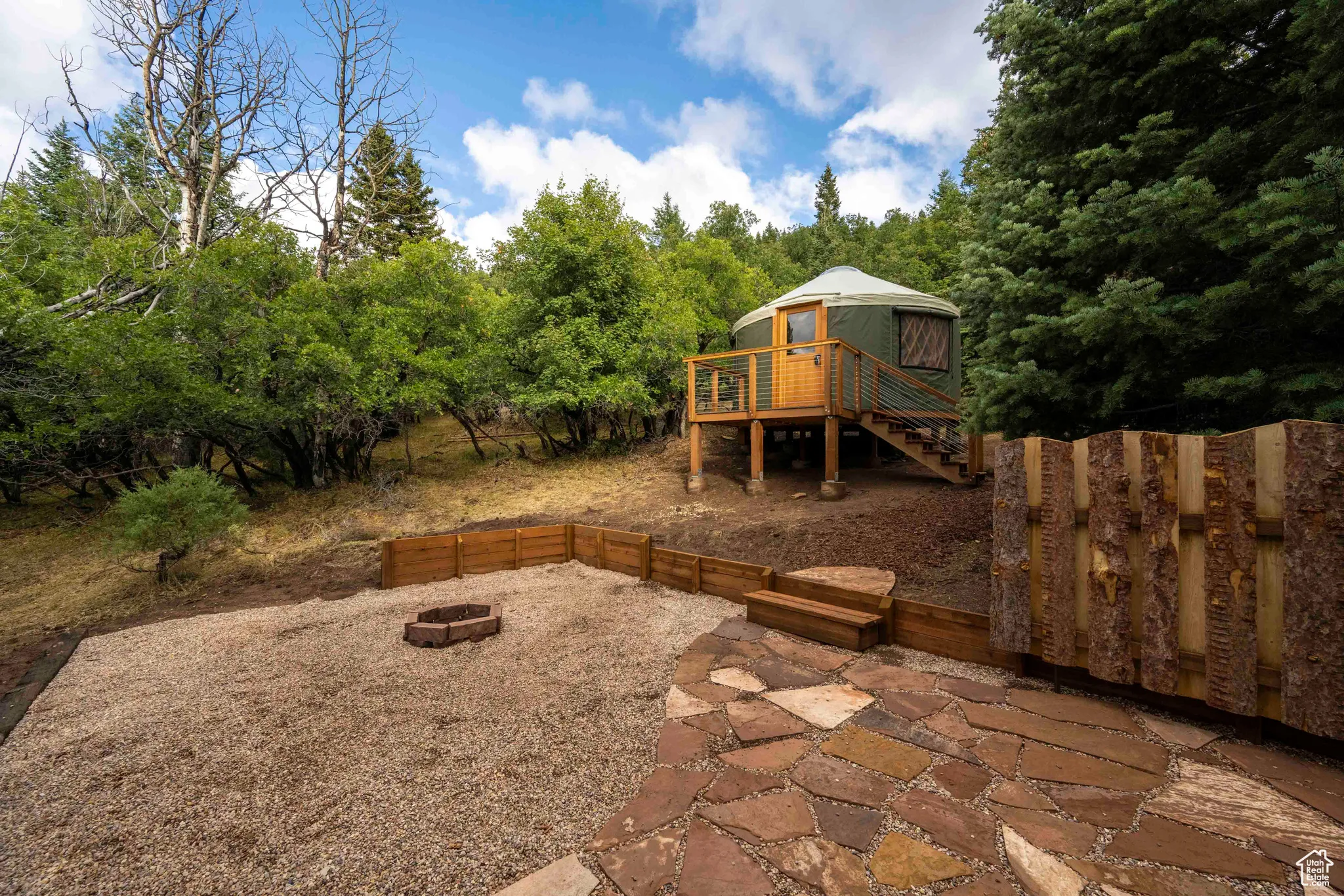 View of patio featuring stairs, an outdoor fire pit, and a deck