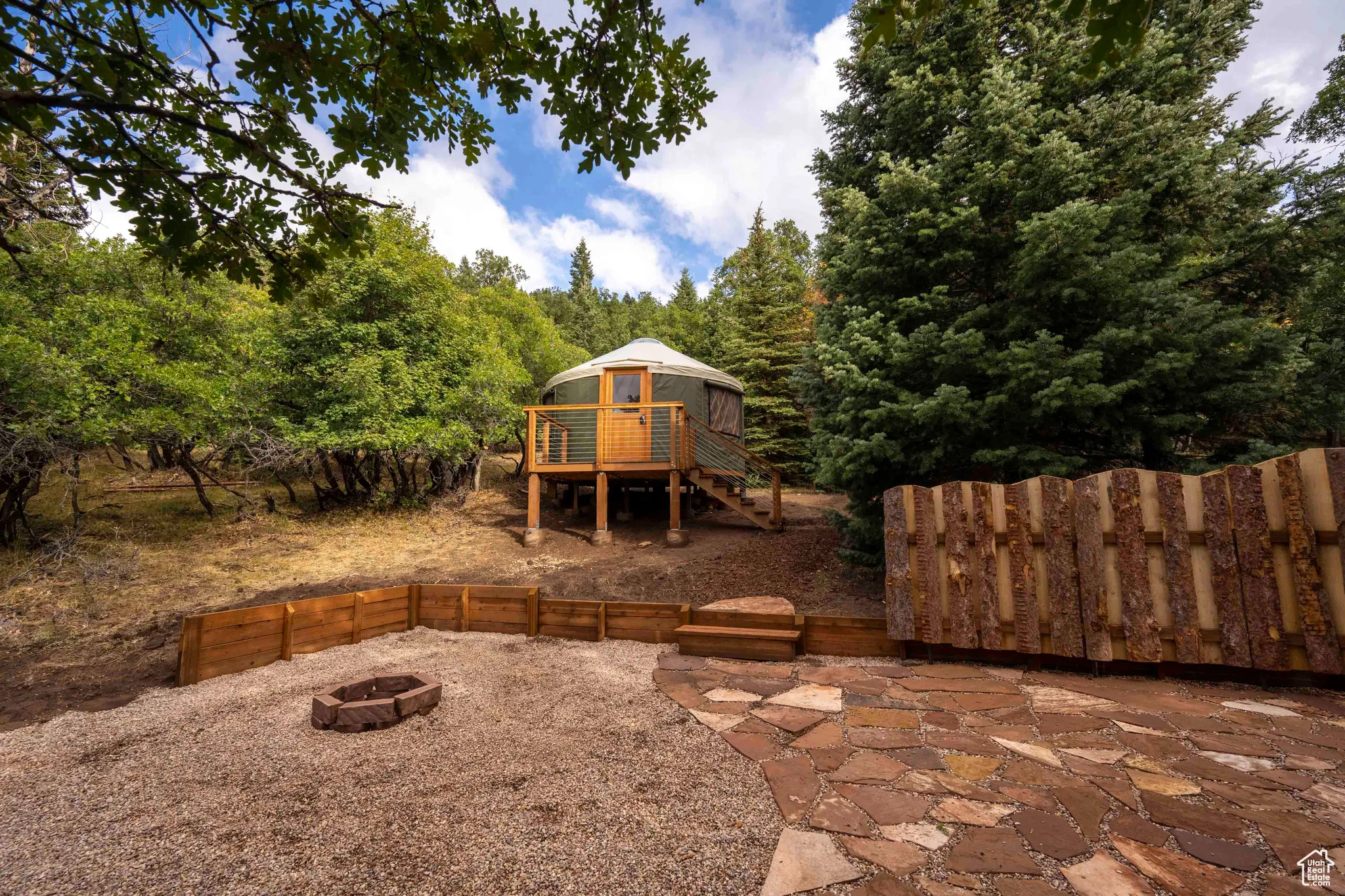 View of yard with an outdoor fire pit, stairway, and a wooden deck