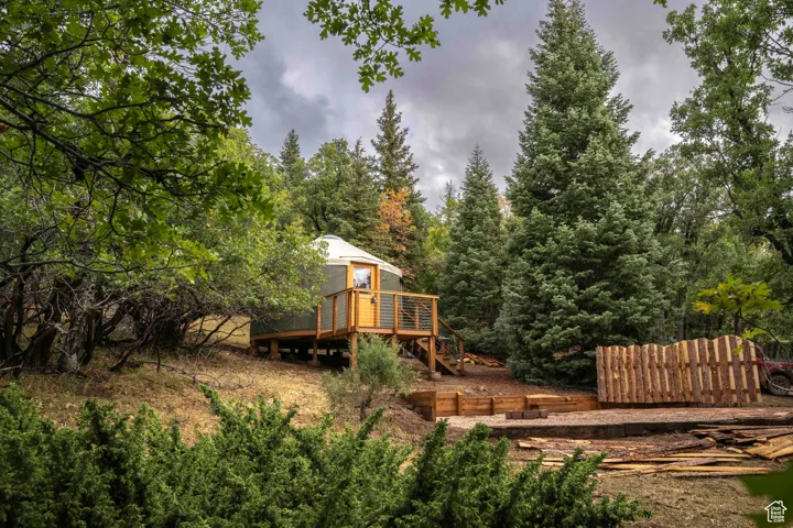 View of yard featuring a deck and a view of trees