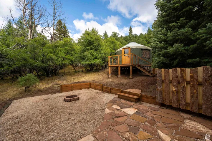 View of patio featuring stairs, an outdoor fire pit, and a deck