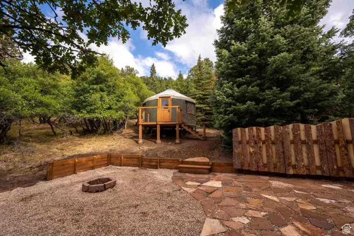 View of yard with an outdoor fire pit, stairway, and a wooden deck