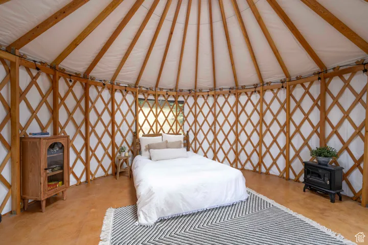 Bedroom featuring a wood stove and vaulted ceiling