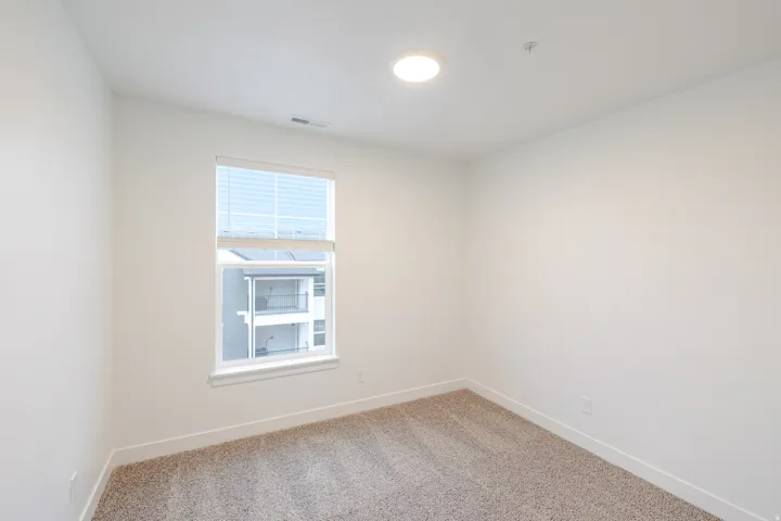 Unfurnished room with baseboards and light carpet