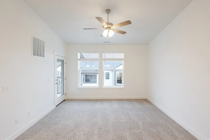 Spare room with light colored carpet and a ceiling fan