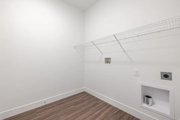 Laundry room featuring dark wood-type flooring, hookup for a washing machine, and electric dryer hookup