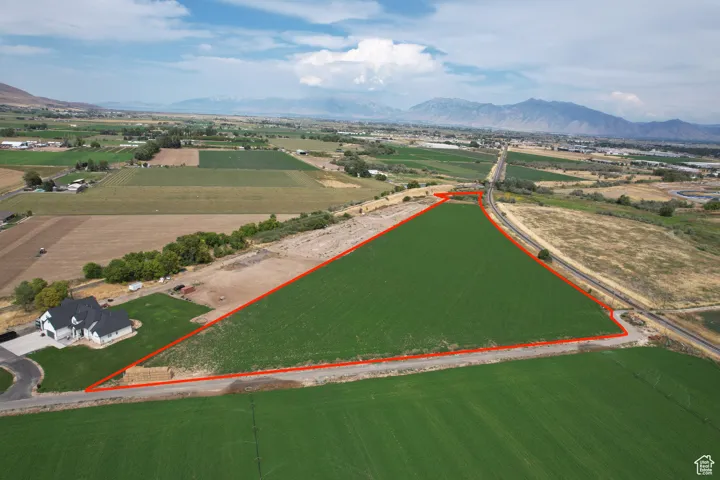 View of rural area with a mountain backdrop, rows of crops, and property boundaries highlighted