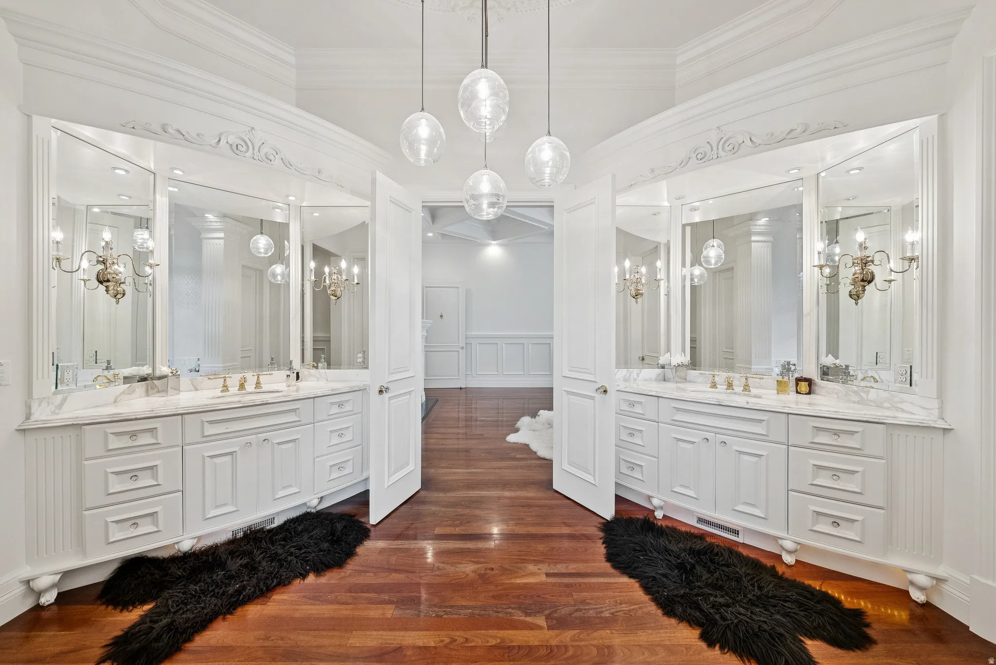 Dual vanities featuring white cabinetry, stone countertops, and integrated sinks