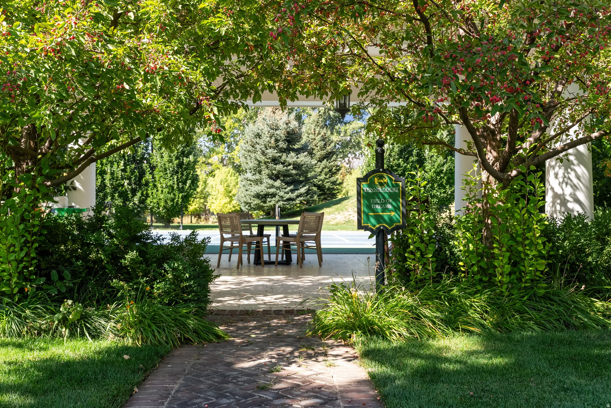 Brick pathway leading to a covered patio area with a dining table and chairs
