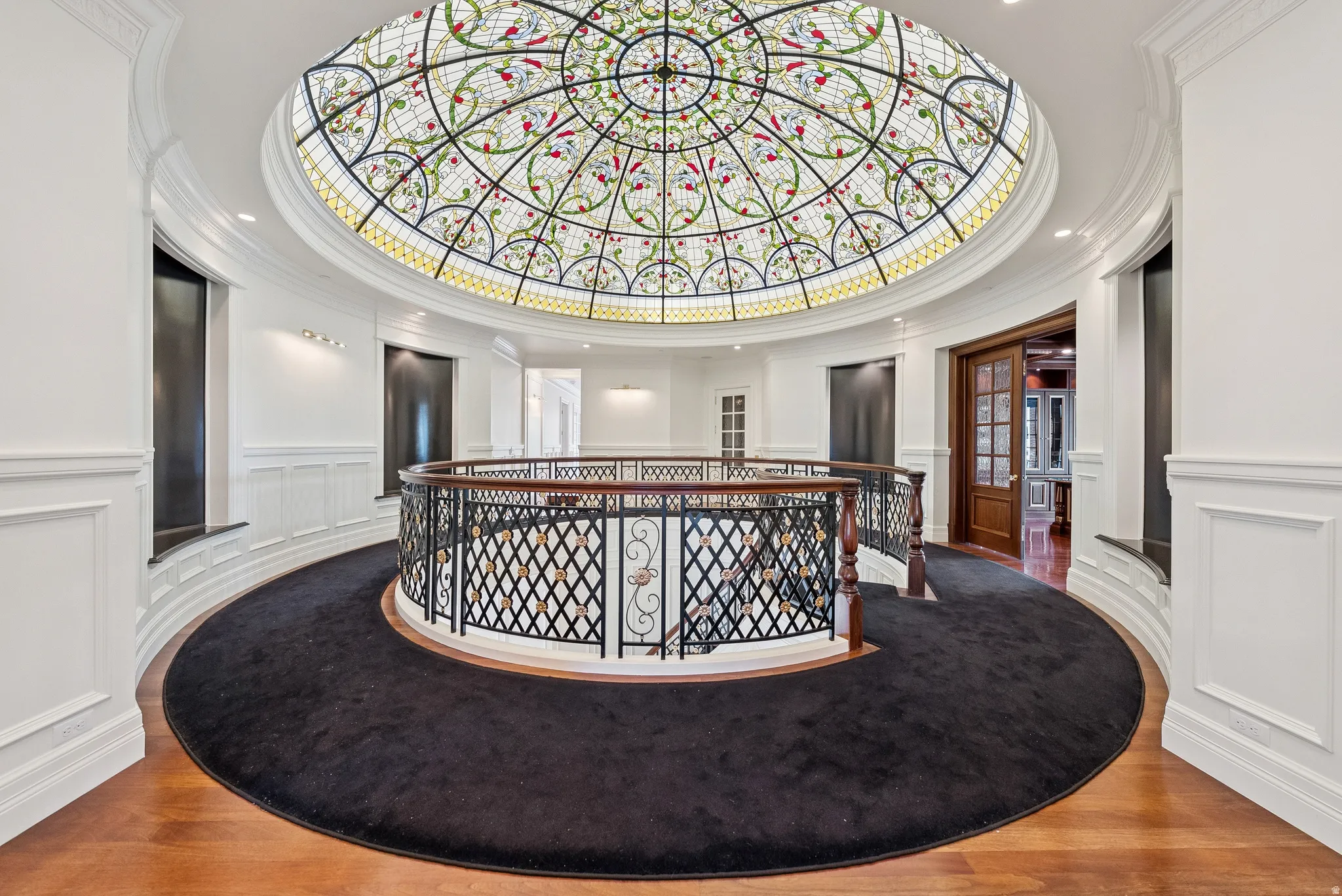 Ornate stained-glass dome ceiling crowning a grand circular hallway