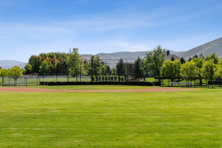 Expansive green lawn with a dirt infield