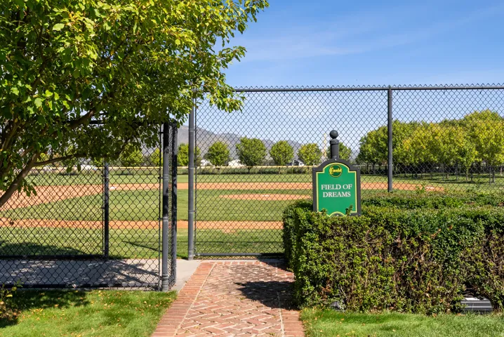 Baseball field with a chain-link fence, green outfield, and dirt infield