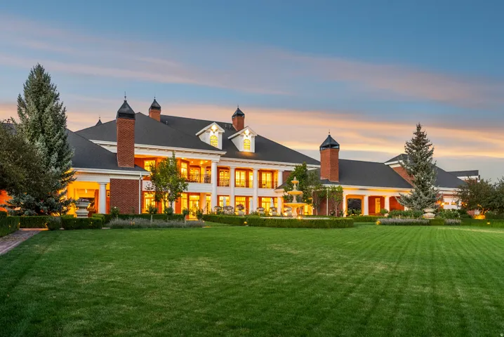 Expansive green lawn fronting a grand brick and white-columned estate