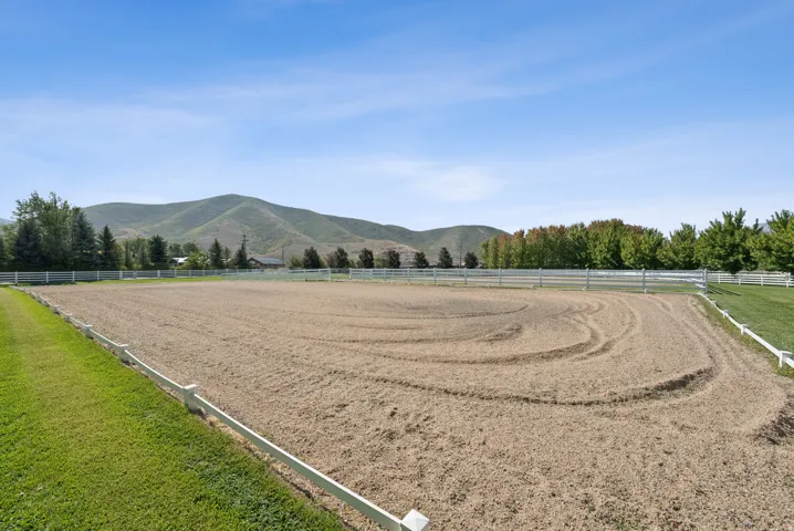 Expansive outdoor arena featuring sand footing and white perimeter fencing