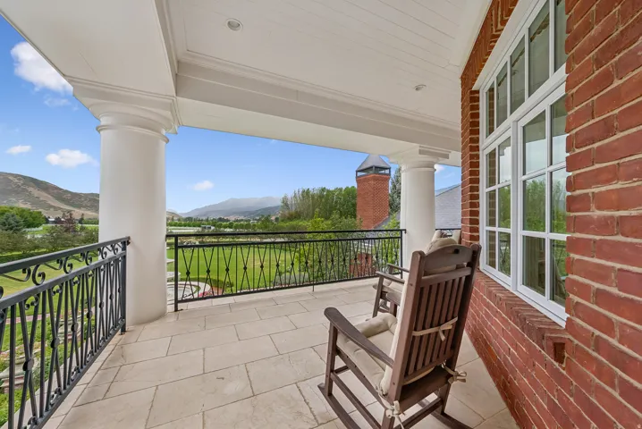 Covered balcony featuring substantial columns and a full brick exterior