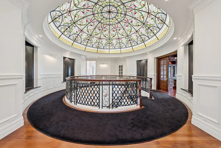 Ornate stained-glass dome ceiling crowning a grand circular hallway