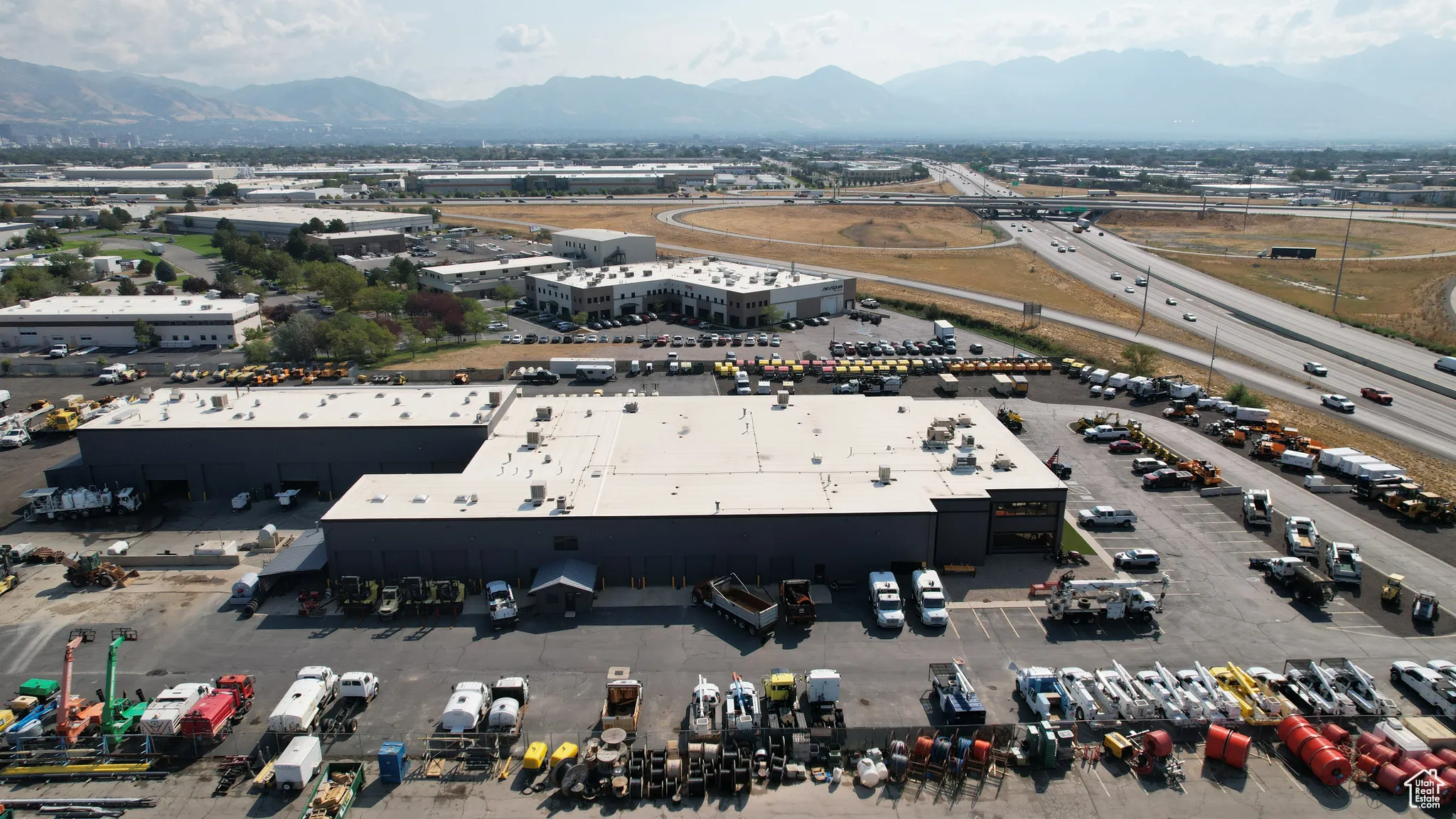 Drone / aerial view of industrial structures and a mountainous background
