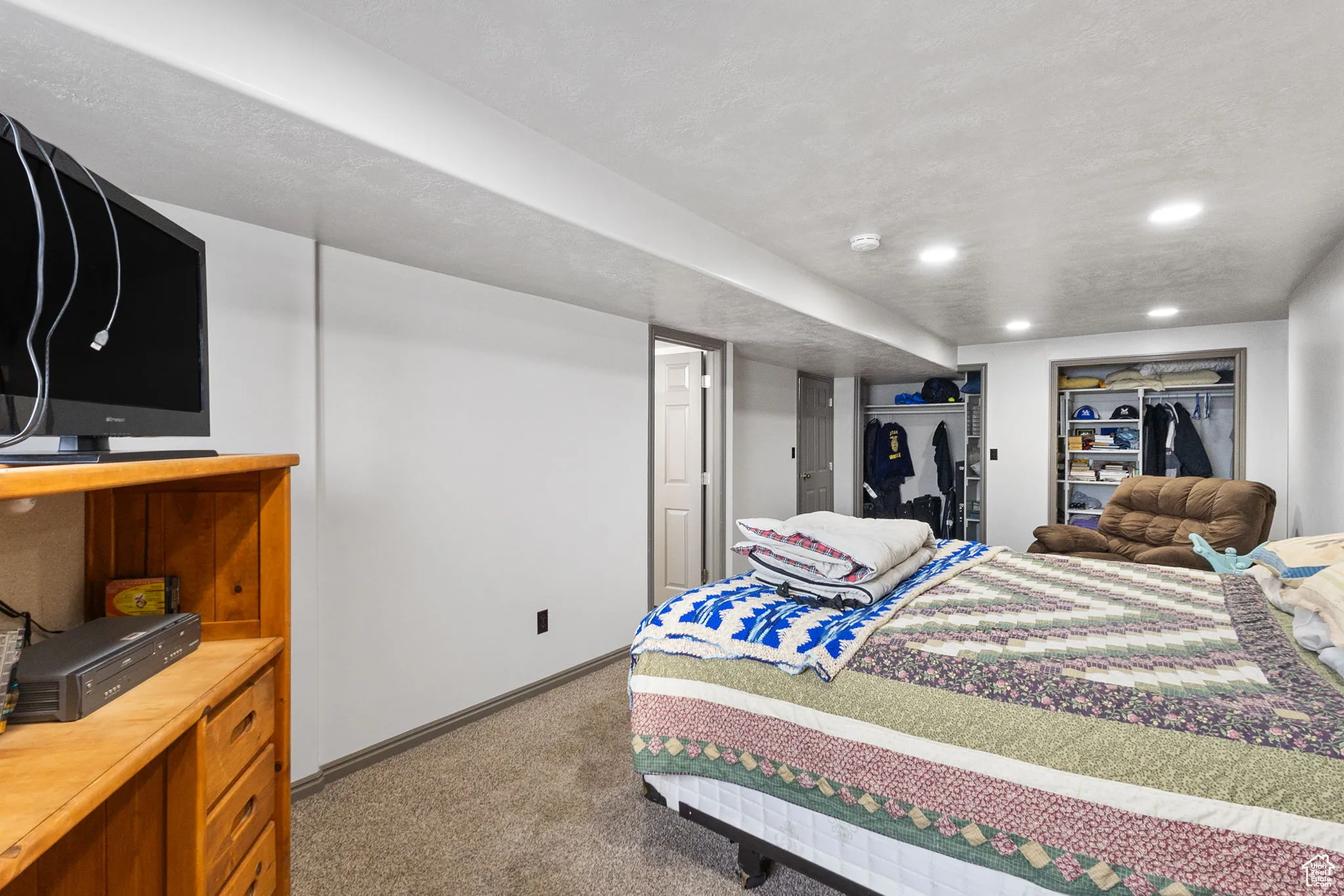 Bedroom with dark colored carpet, recessed lighting, and a textured ceiling