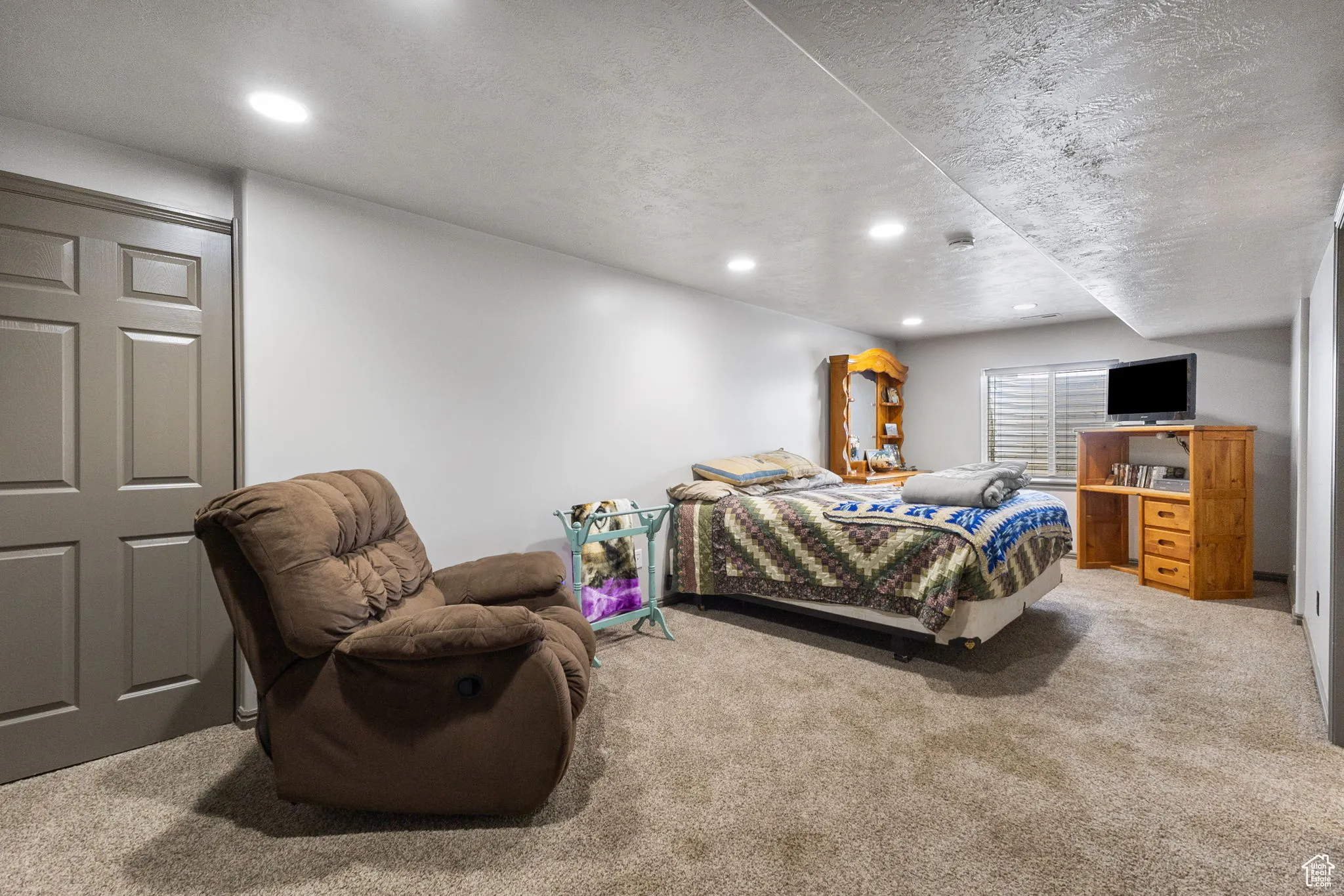 Bedroom with carpet floors, a textured ceiling, and recessed lighting