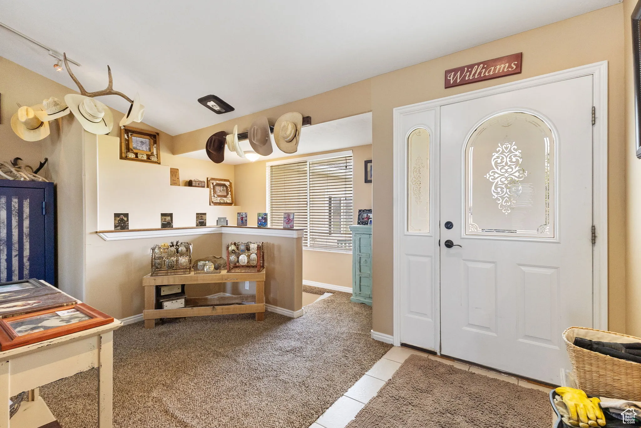 Entrance foyer featuring light tile patterned floors and light colored carpet