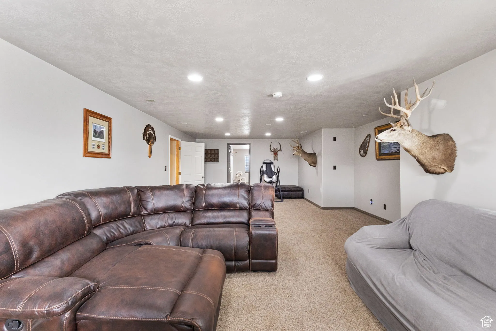 Living area with light colored carpet, recessed lighting, and a textured ceiling