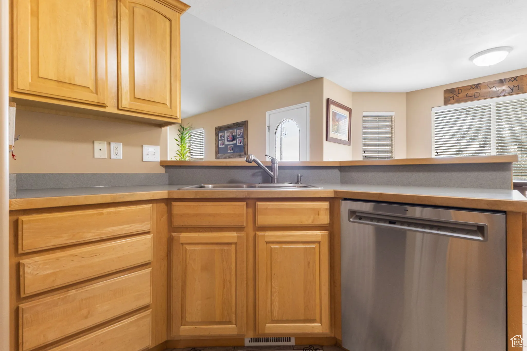 Kitchen featuring dishwasher, light brown cabinets, and a peninsula