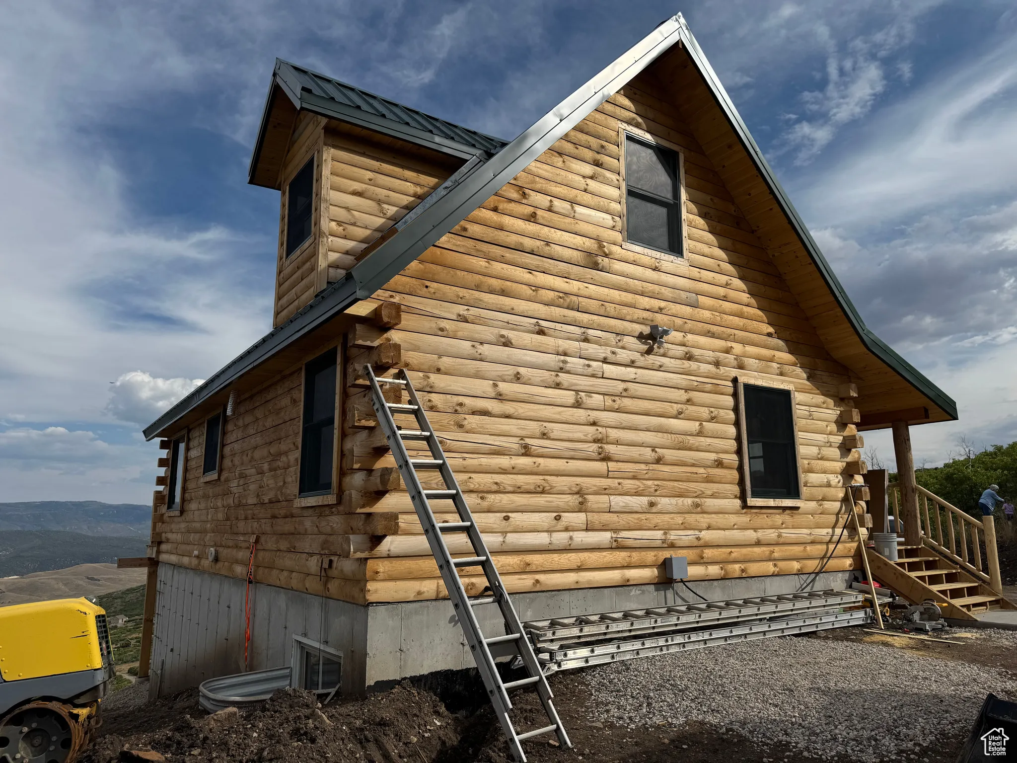 View of side of home with a metal roof and log exterior