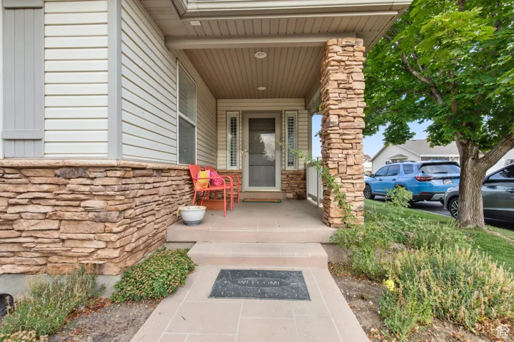 Entrance to property featuring stone siding and a porch