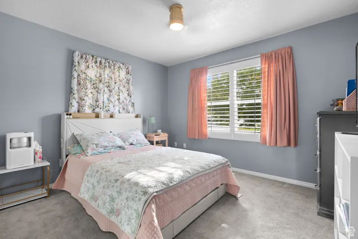 Carpeted bedroom with baseboards and a textured ceiling