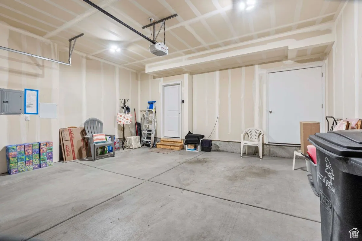 Garage featuring electric panel and a garage door opener