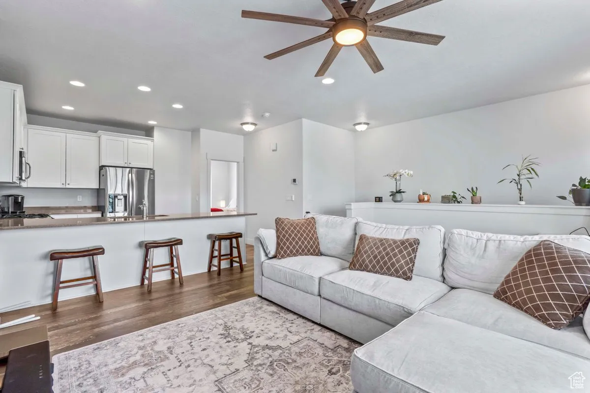 Living area with dark wood-style floors, recessed lighting, and a ceiling fan