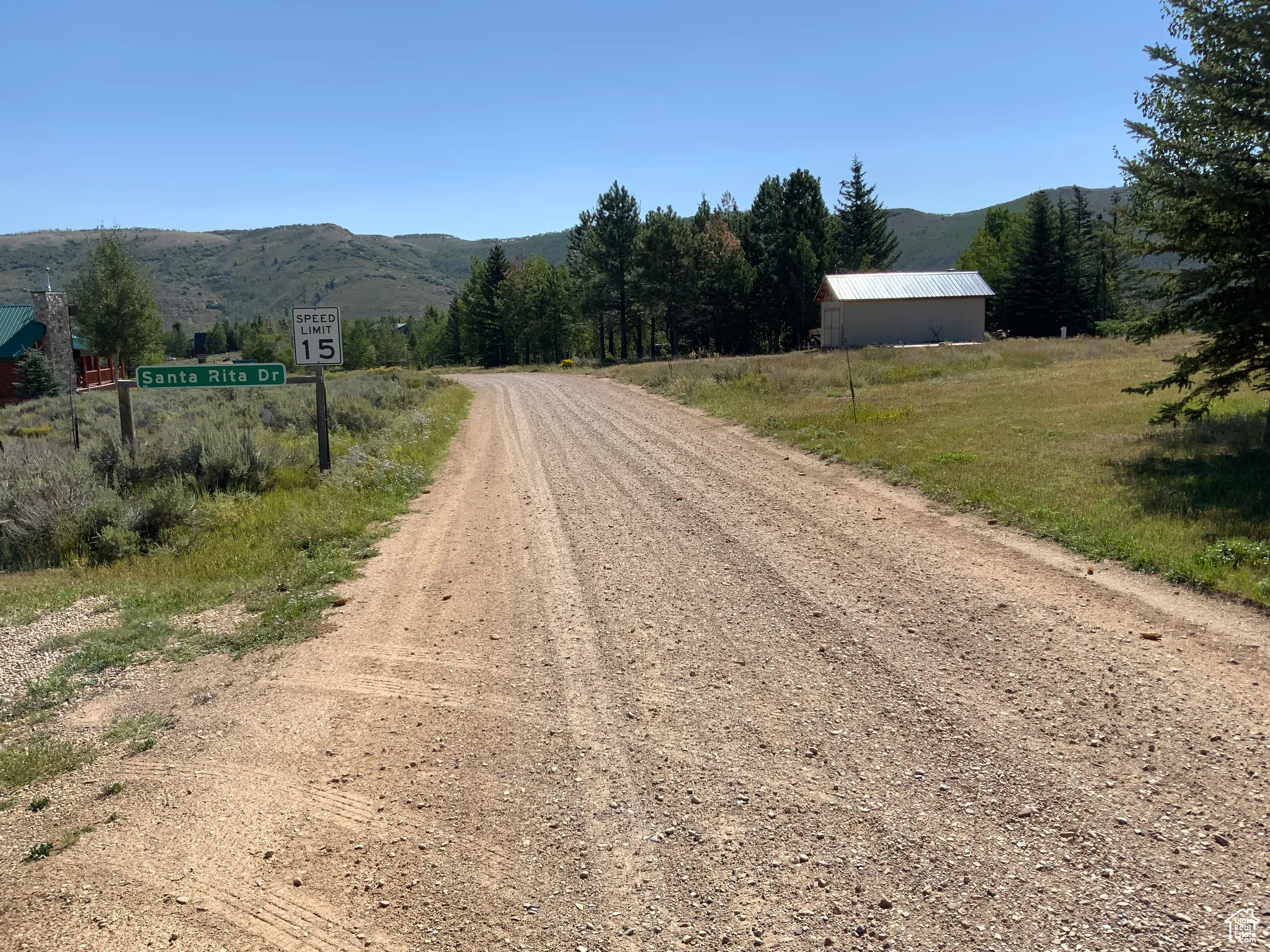 View of dirt / gravel road with a mountain view and a view of countryside