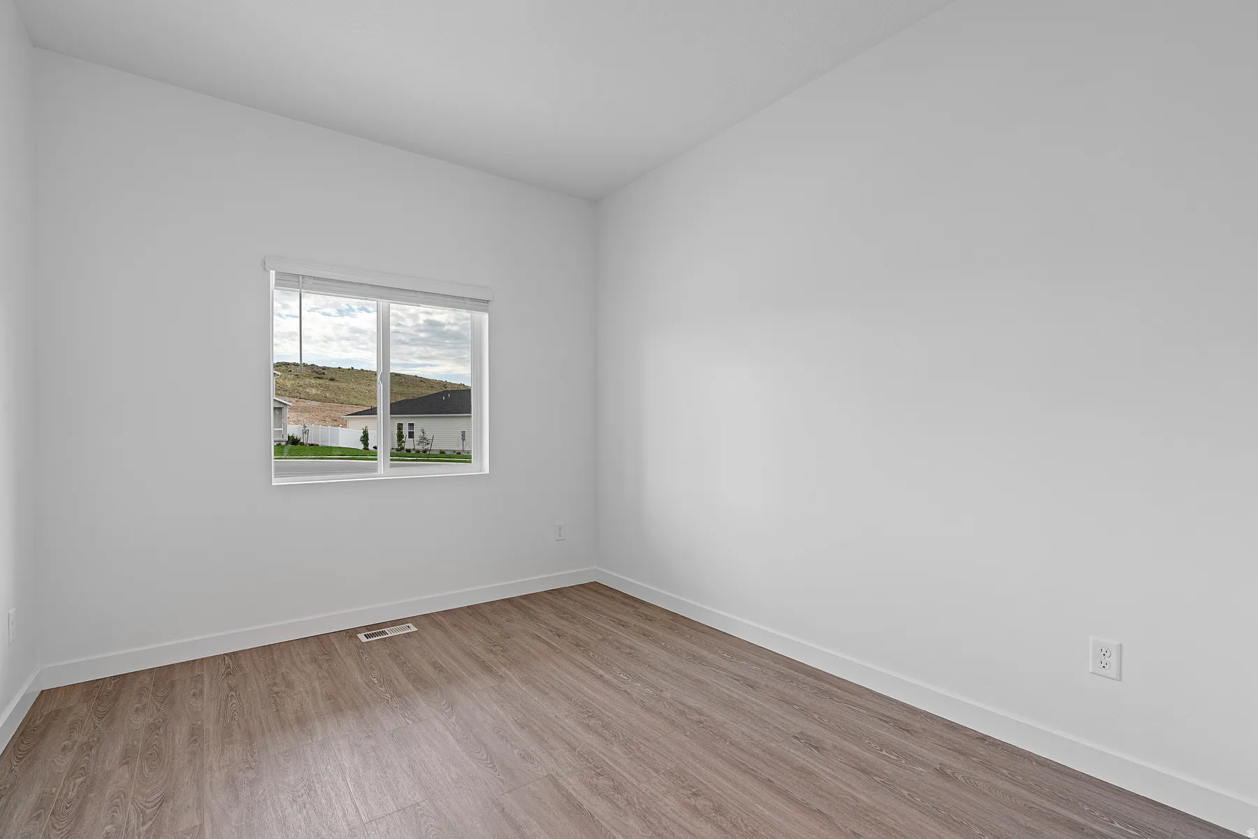 Spare room with baseboards and light wood-style floors