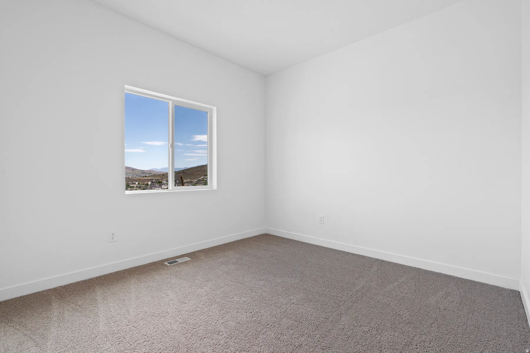 Spare room featuring carpet flooring and a mountain view
