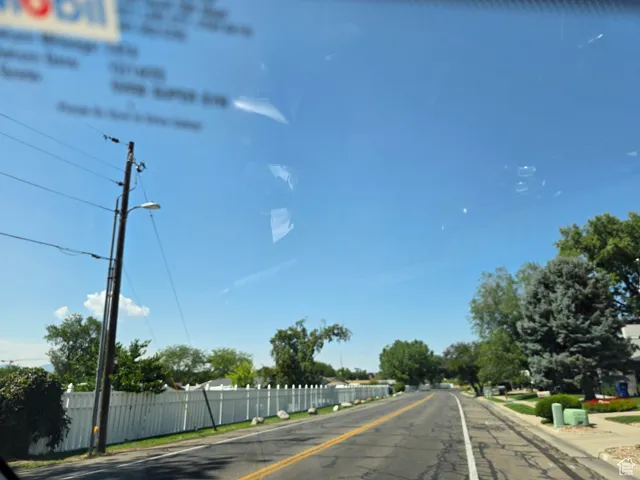 View of asphalt street with sidewalks, curbs, and street lights