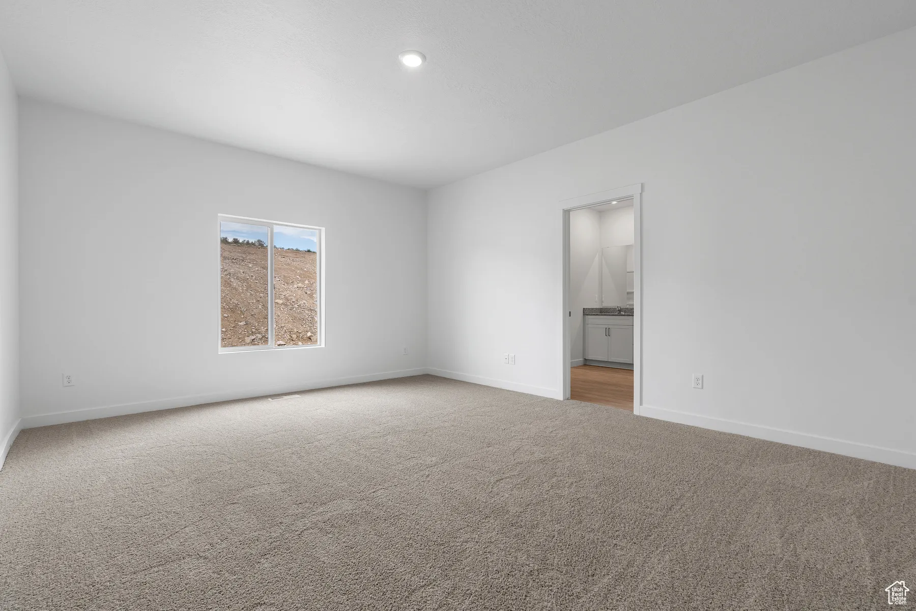Unfurnished bedroom with light carpet, recessed lighting, and ensuite bath